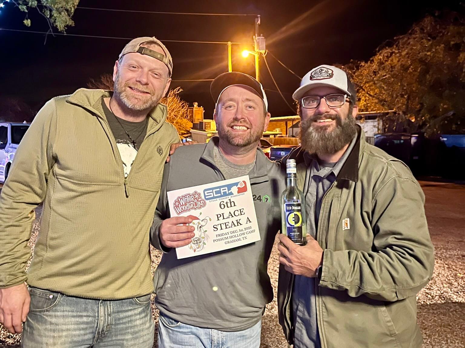 Three cooks holding a sixth-place certificate and trophy at the Winter Wonderland Cookoff