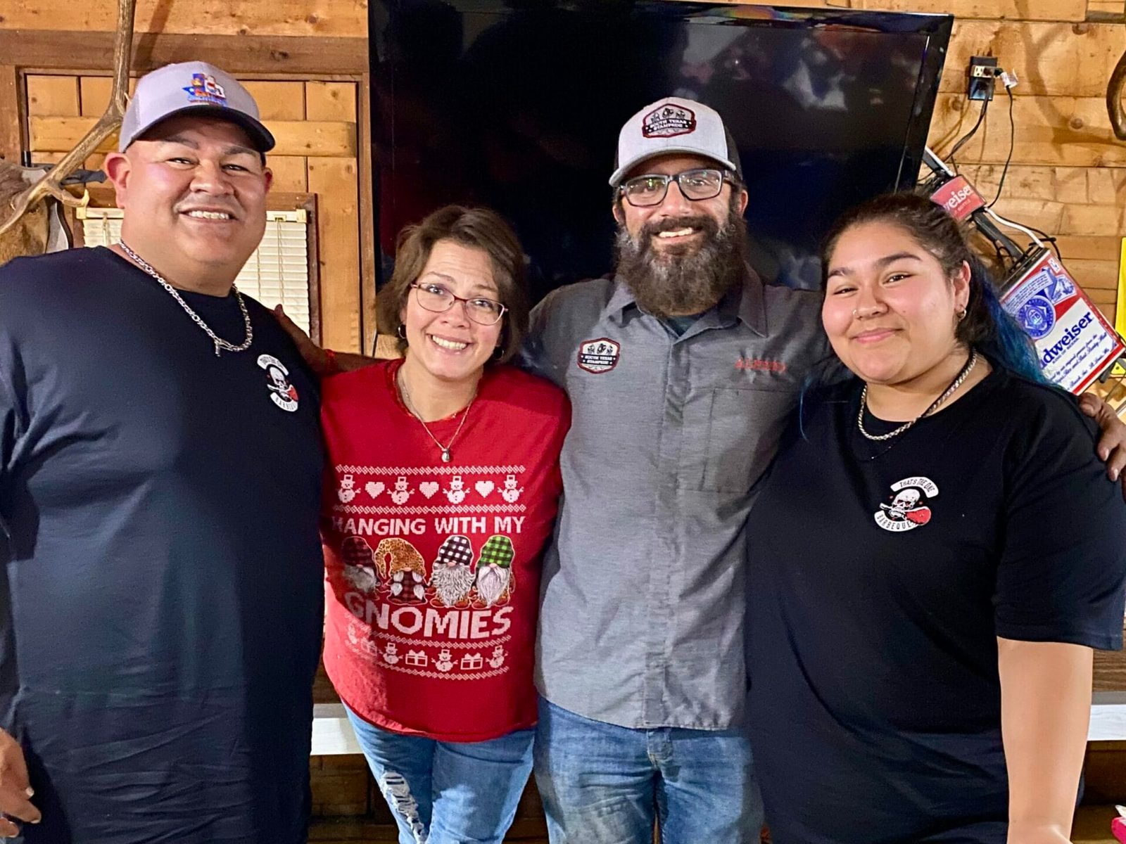 Four cooks gathered together in holiday clothing at the Winter Wonderland Cookoff